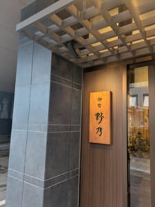御宿野乃富山の入口。木の格子天井と「御宿 野乃」の看板