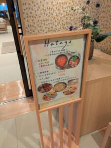 御宿野乃富山の朝食会場「Hatago」入口の案内。営業時間と朝食料金